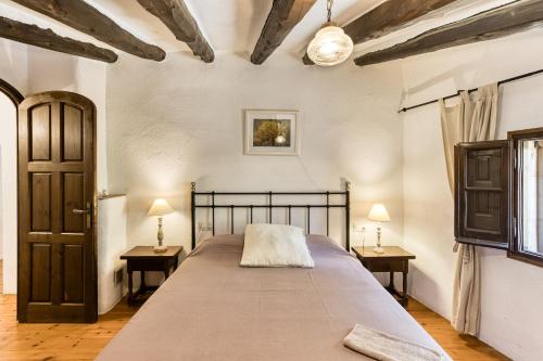 a bedroom with a large bed and two tables at El Revolt de Martís in Esponellá