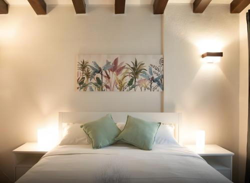 a bedroom with a bed with two green pillows at La Ginestra Appartamenti e Camere in Mossa