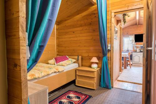 a bedroom with a bed in a wooden house at Kleines Gästehaus in Sudwalde