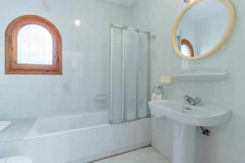 a white bathroom with a sink and a mirror at Villa Rosa in Benissa