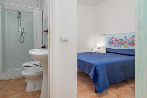 a bathroom with a bed and a toilet and a sink at New Villa Carmen in San Teodoro