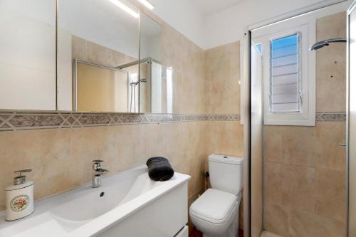 a bathroom with a toilet and a sink and a mirror at Tamaragua in Candelaria