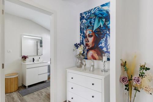a bathroom with a painting of a woman on the wall at Cantinho D'Amy in Arcos de Valdevez