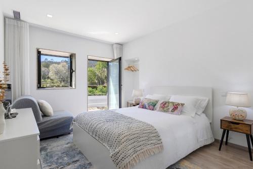 a white bedroom with a bed and a window at Cantinho D'Amy in Arcos de Valdevez