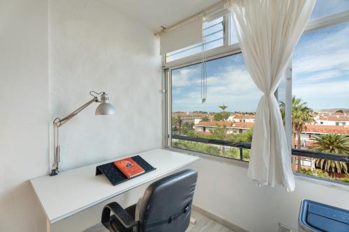 a desk with a book and a lamp and a window at Casa Candido in Arona