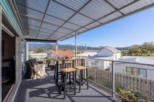 a pergola on a balcony with a table and chairs at Wharf Landing - Harbour View with Sunny Balcony, Walk to Town in Coromandel Town