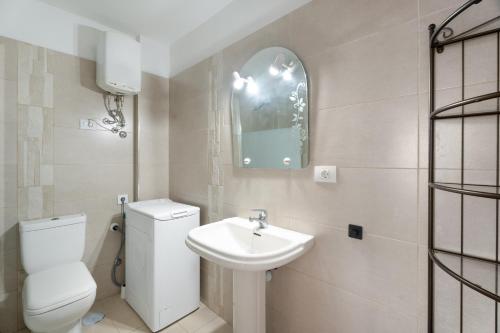 a white bathroom with a toilet and a sink at Casa Candido in Arona
