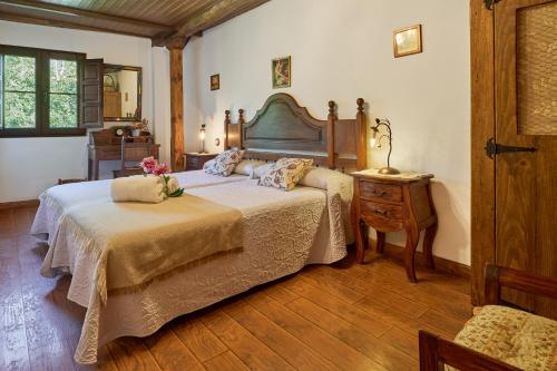 a bedroom with a large bed and a table at El Pajariel I in Valdecañada