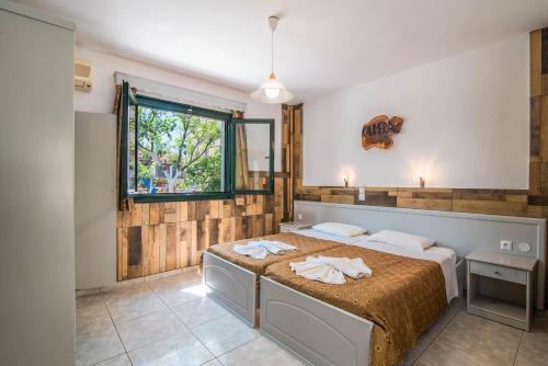 a bedroom with a bed and a window at Mirage Arillas Studio Type A4 in Arillas