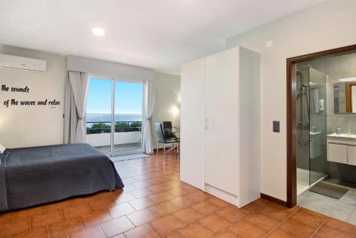 a bedroom with a bed and a view of the ocean at Ninho Gaivota in Porto Moniz