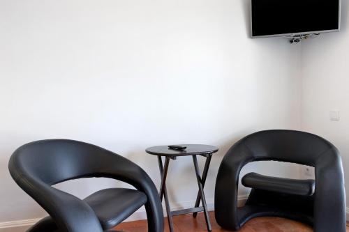 two black chairs sitting next to a table with a tv at Casa Vasconcelos in Afife