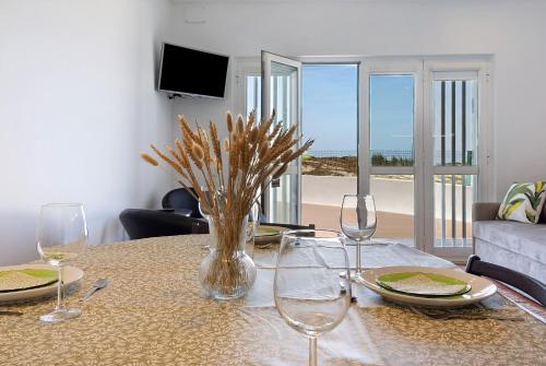 a table with glasses and a vase of flowers on it at Casa Vasconcelos in Afife