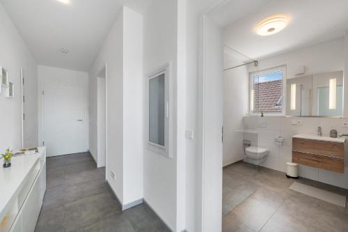 ein weißes Badezimmer mit Waschbecken und Toilette in der Unterkunft Katharinenbergblick in Endingen