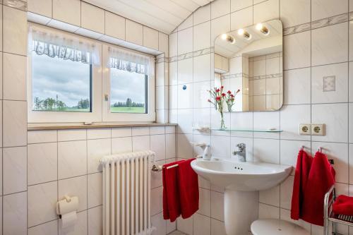 a white bathroom with a sink and a mirror at Haus Scherer in Sankt Peter