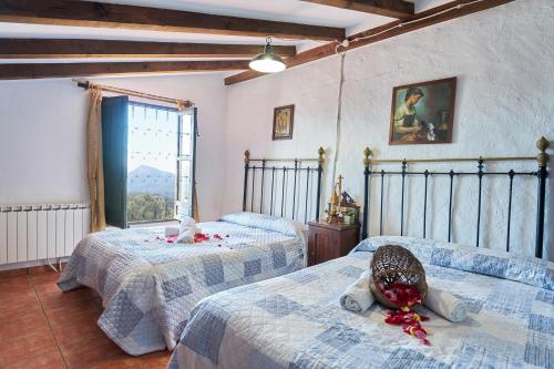 a bedroom with two beds and a window at La Sierrezuela in Castillo de Locubín