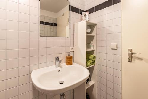 a white bathroom with a sink and a mirror at Ferienwohnung Fetscher 1 in Reichenau