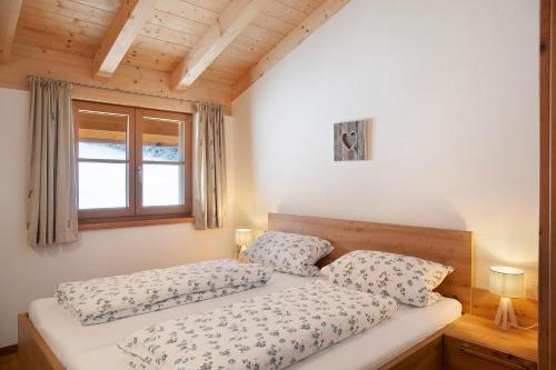 a bedroom with two beds and a window at Ferienwohnung Bergenzian in Grainau