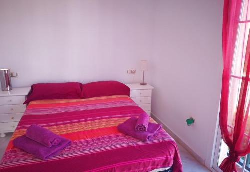 a bedroom with a bed with purple pillows on it at Casa Danca Cabopino in Marbella