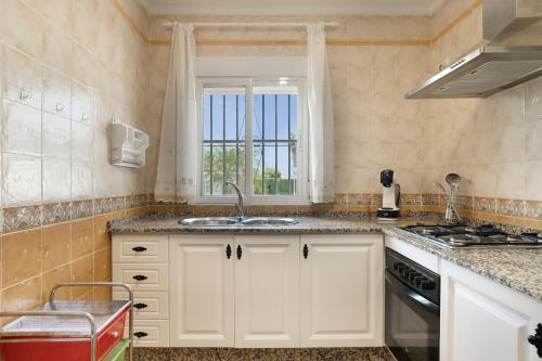 a kitchen with white cabinets and a sink and a window at Casa Alfonso Manuel in Roche