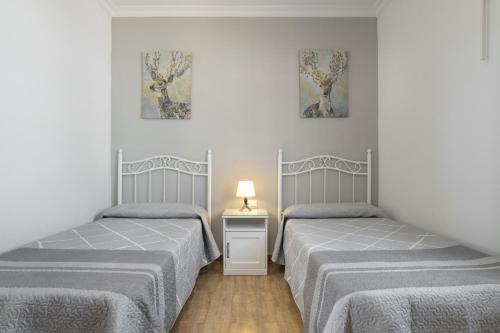a room with two beds and a table with a lamp at Casa Alfonso Manuel in Roche