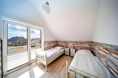a bedroom with two beds and a large window at Boje by Seeblick ferien oro in Kappeln