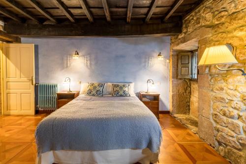 a bedroom with a bed in a stone wall at La Casona De Barrio in Barrio