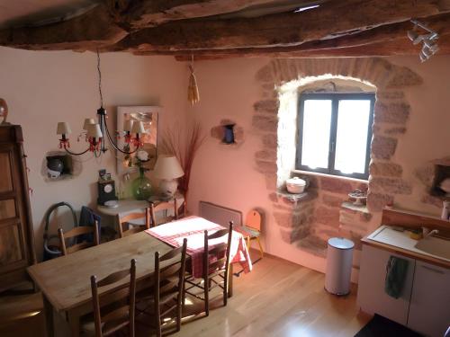 a kitchen and dining room with a table and a window at Maison Typique Au Calme in Coubisou