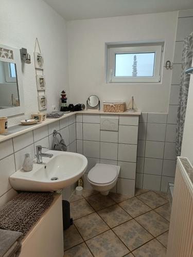 a white bathroom with a toilet and a sink at Apartment Casa Gina in Stockach