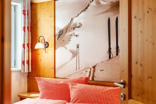 a bedroom with a bed with a painting on the wall at Alpenflora 2 in Ischgl