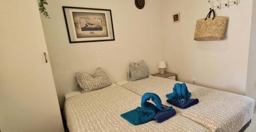 a bedroom with two beds with blue bags on them at La Cala Apartment in La Cala de Mijas