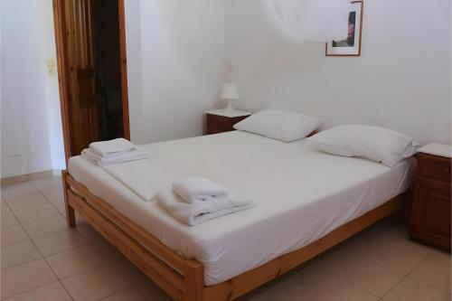 a bed with white sheets and towels on it at Villa Milia in Agios Nikitas