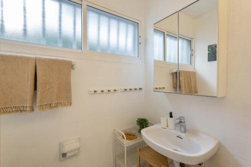 a white bathroom with a sink and a mirror at Al Mar en San Agustín in San Bartolomé