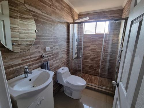 a bathroom with a toilet and a sink and a mirror at Casa campo Quillota in Quillota
