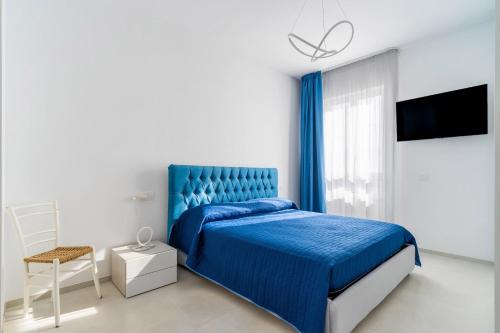 a bedroom with a blue bed and a chair at Suite Buena Vista in Gallipoli