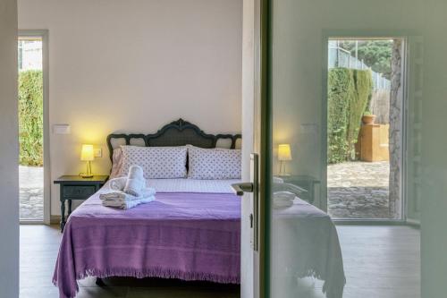 a bedroom with a bed with a purple bedspread at Apartamento Bajo 3 in Begur