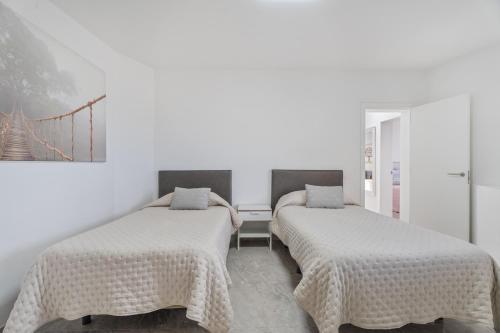 two beds in a room with white walls at Casa Miramar in Frontera
