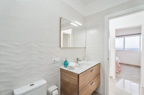 a white bathroom with a sink and a mirror at Casa Miramar in Frontera