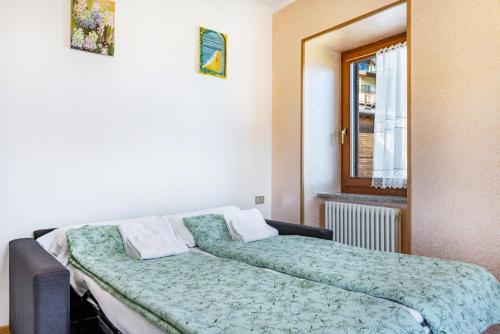 a bedroom with a bed and a window at Appartamenti l'Edera in Cavedago