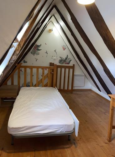 a room with a bed in the attic at Gîte Rosa Bonheur in Saint-Cernin