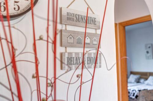 a clock hanging on a wall with signs on it at Camí d'es Torres in Portopetro