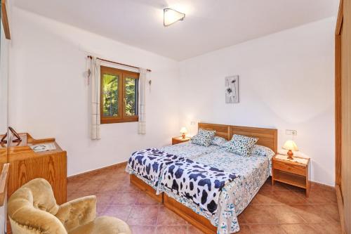 a bedroom with a bed and a chair at Camí d'es Torres in Portopetro