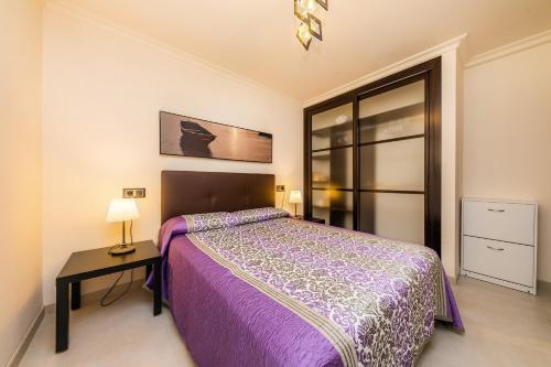 a bedroom with a purple bed and a table at Neo in Cala Ratjada
