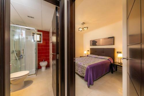 a bedroom with a bed and a bathroom with a toilet at Neo in Cala Ratjada