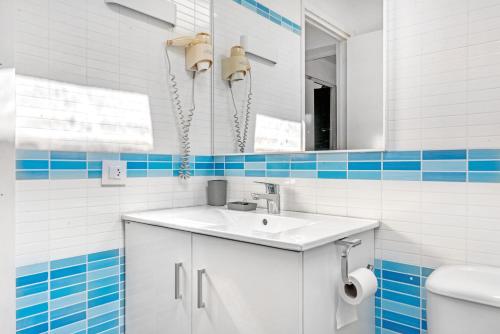 a bathroom with a sink and a mirror and a toilet at Sa Calma House in Cala en Bosc