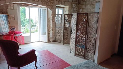 a room with wooden dividers in a room with a window at Chambre Hirondelle in L'Ile-Bouchard