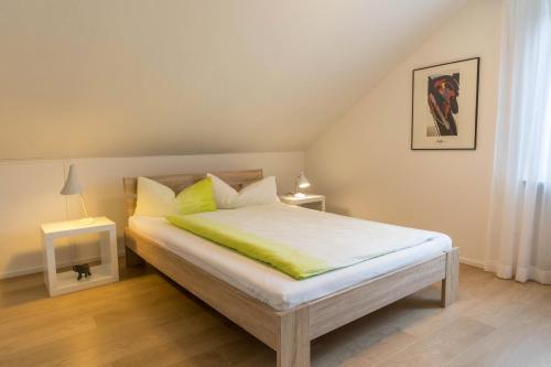 a bedroom with a large bed with yellow pillows at Ferienwohnung Lumafe in Überlingen