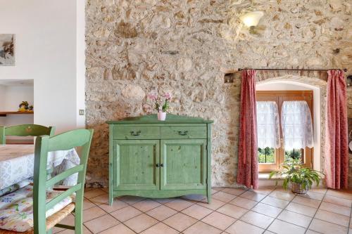 a bedroom with a green cabinet and a window at Rustico Spagnol 4 in Tignale