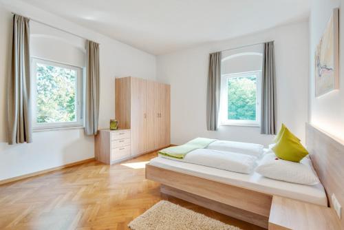 a bedroom with a bed and two windows at Ferienwohnung Daniela in Merano