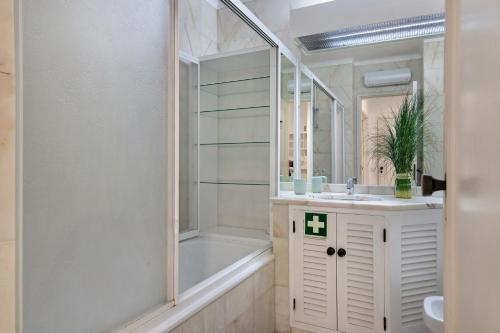 a bathroom with a tub and a sink and a shower at Apartamento Nautilus in Armação de Pêra