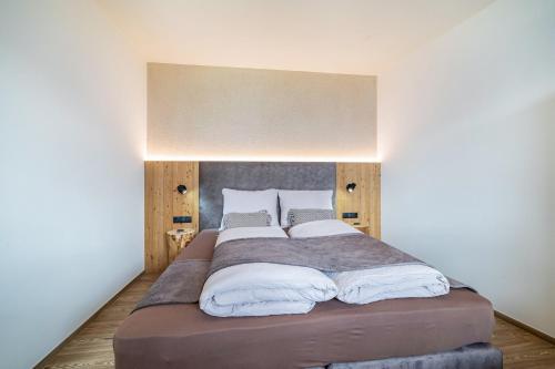 a bedroom with a large bed with white pillows at Paflur Lodges Lärchenduft in Lasa